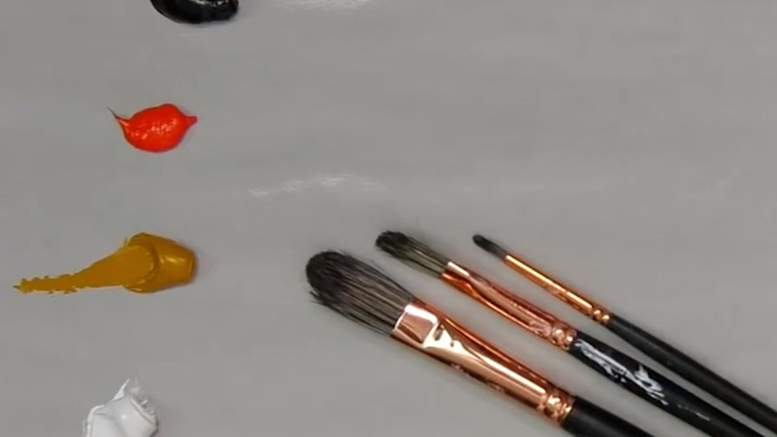 لمسات من الألوان الأساسية وفرش رسم على سطح أبيض نظيف