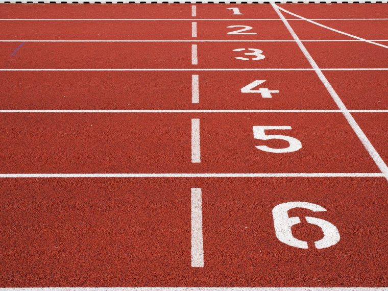 مضمار جري أحمر بأرقام الحارات البيضاء من واحد إلى ستة